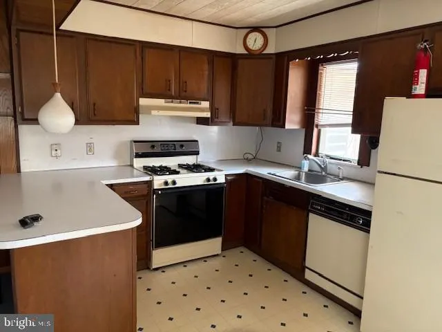 a kitchen with granite countertop a refrigerator stove and sink