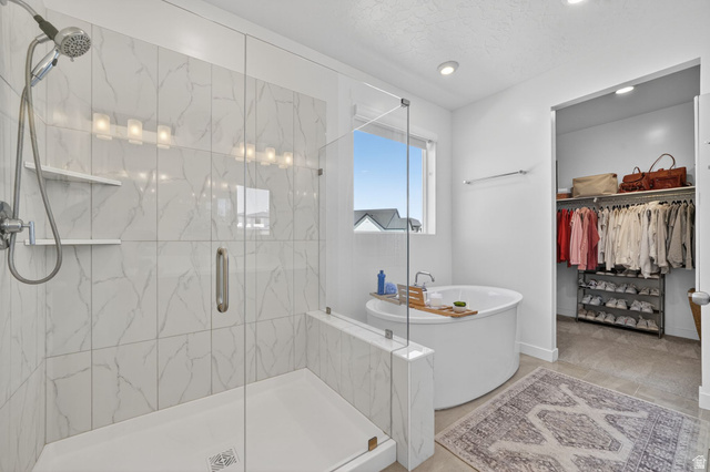 1165 West Union Bench Drive Mapleton, UT 84664 - Photo 25 of 61 Spacious bath featuring a glass-enclosed shower with subway tile surround, a deep soaking tub, and an adjacent walk-in closet with built-in shelving