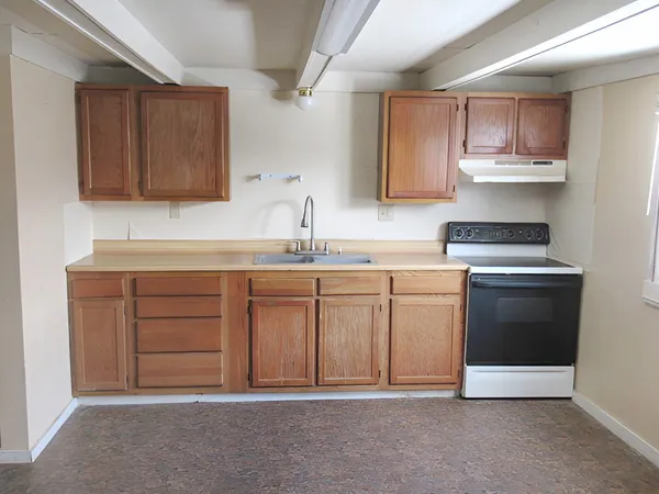 a kitchen with a sink stove and cabinets
