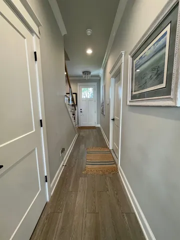 a view of a hallway with wooden floor and staircase