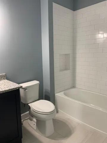 a white toilet and tub sitting next to a bathroom sink