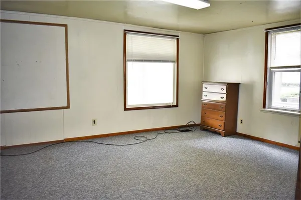 an empty room with windows and closet