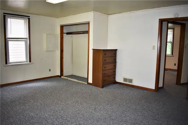 an empty room with windows and closet