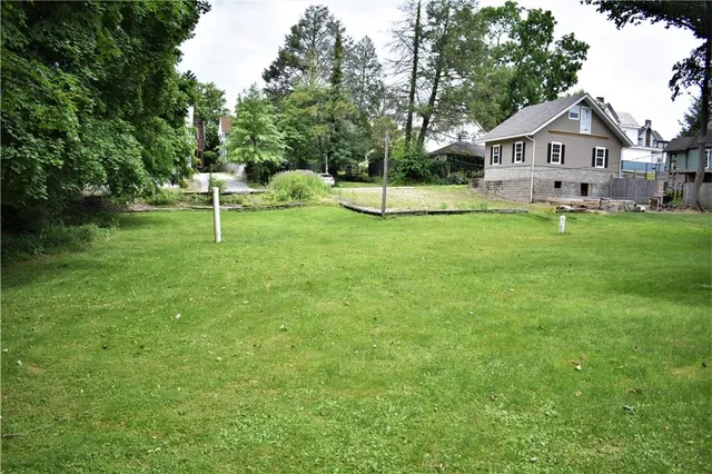 a view of a house with a backyard and a tree