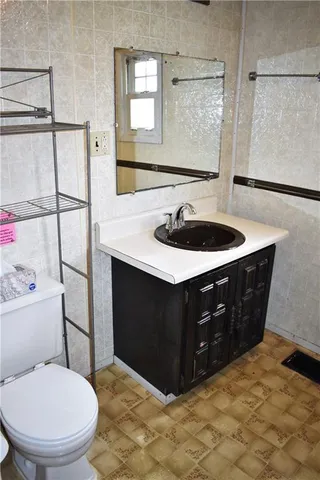 a bathroom with a sink vanity mirror and toilet