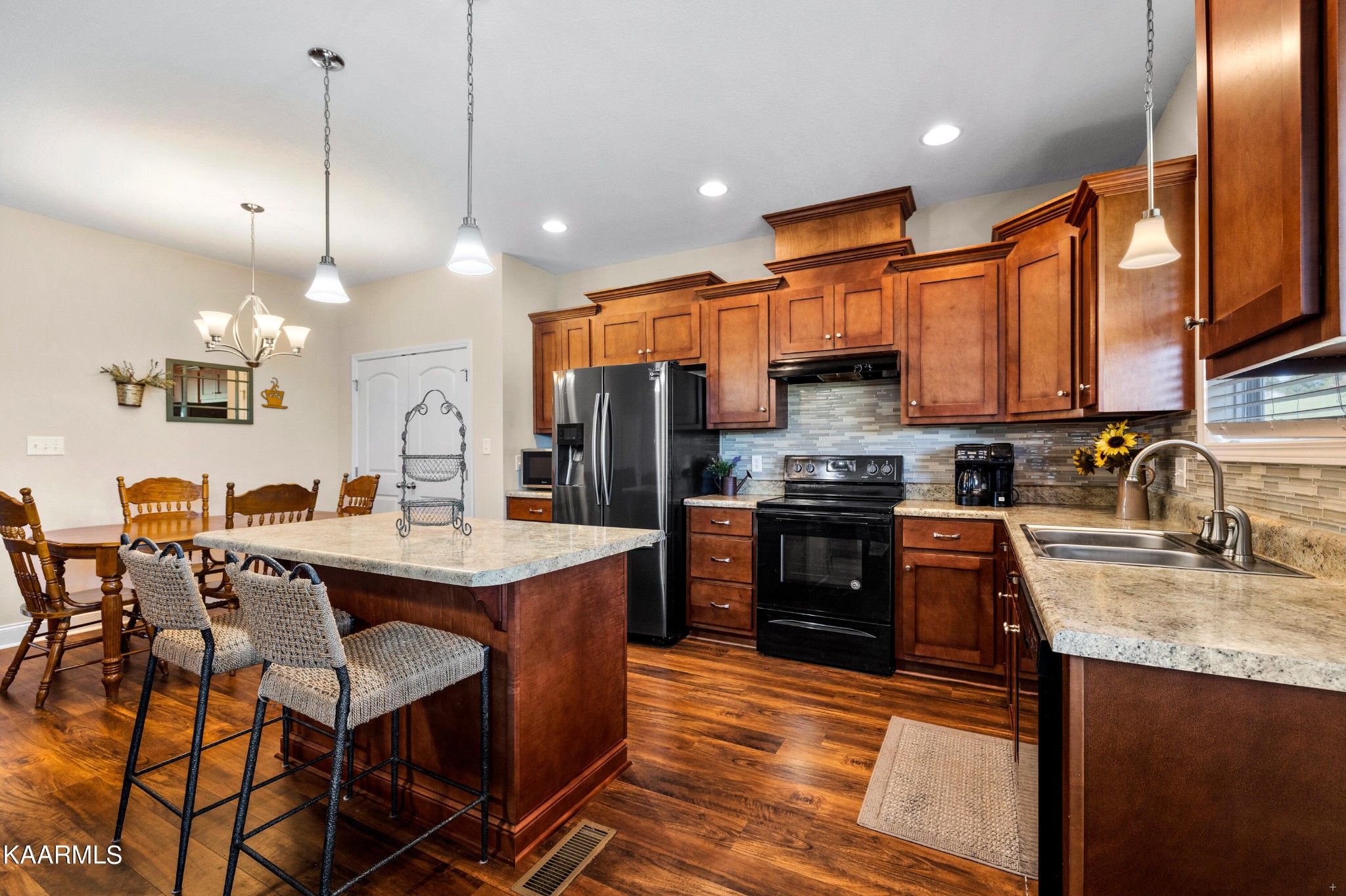820 Kodak Road Kodak, TN 37764 - Photo 12 of 45 a kitchen with stainless steel appliances granite countertop a stove refrigerator a sink a dining table and chairs with wooden floor