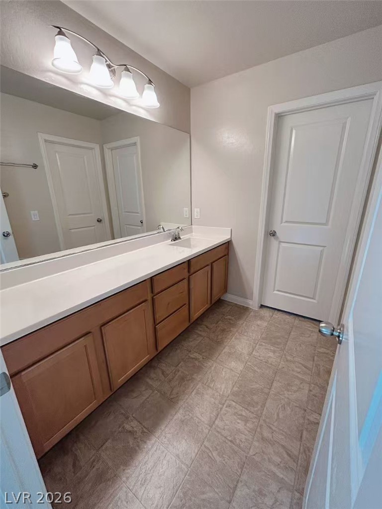 146 Tree Shot Court Las Vegas, NV 89113 - Photo 12 of 18 A well-lit bathroom vanity with an extended mirror and ample storage.