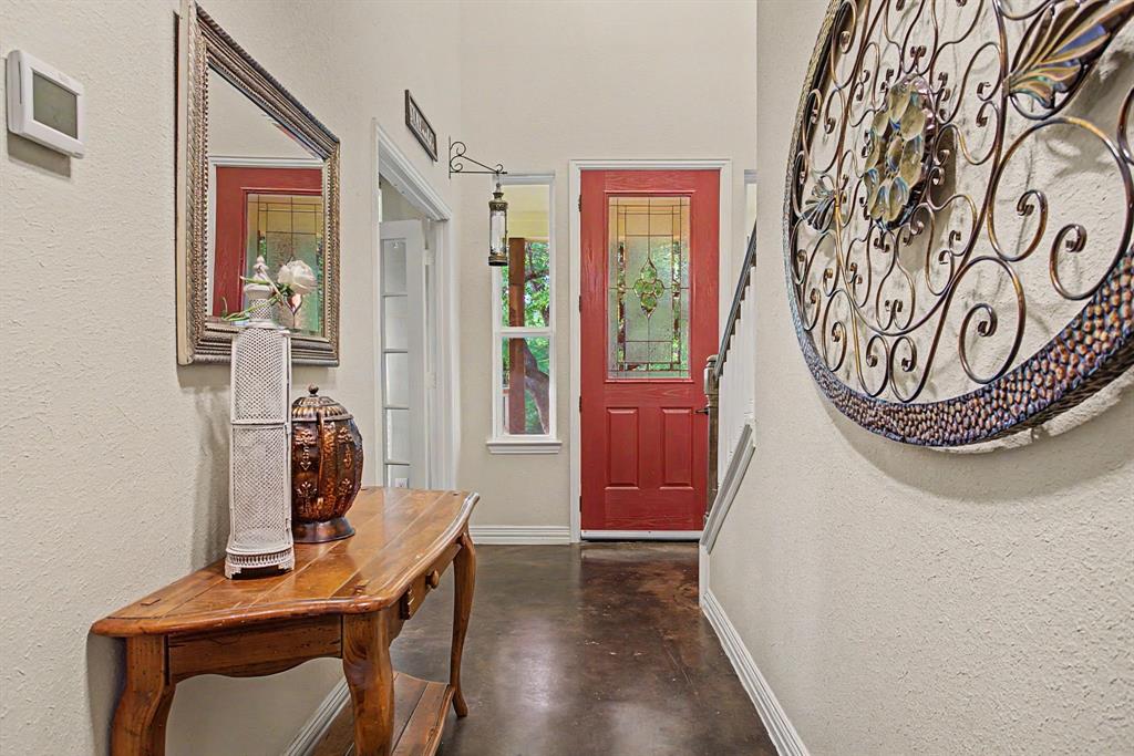 203 Saddle Ridge Court Springtown, TX 76082 - Photo 6 of 39 A farmhouse calls for easy finishes - like stained concrete flooring. And a red door.