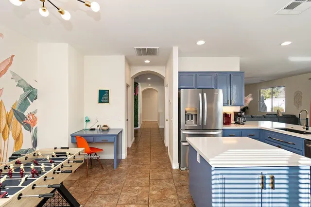 a kitchen with stainless steel appliances kitchen island granite countertop a sink and a refrigerator