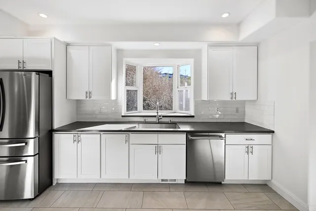 a kitchen with stainless steel appliances granite countertop a stove a sink and a refrigerator