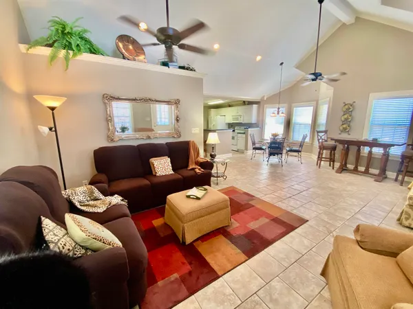 a living room with furniture a chandelier and a rug
