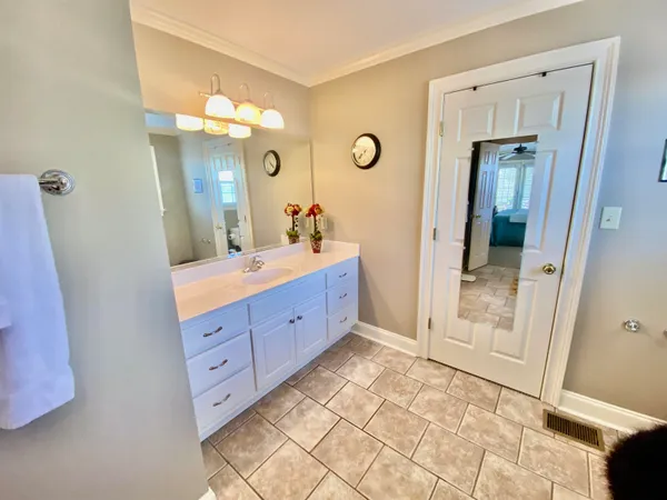 a bathroom with a sink a toilet a mirror a vanity and window