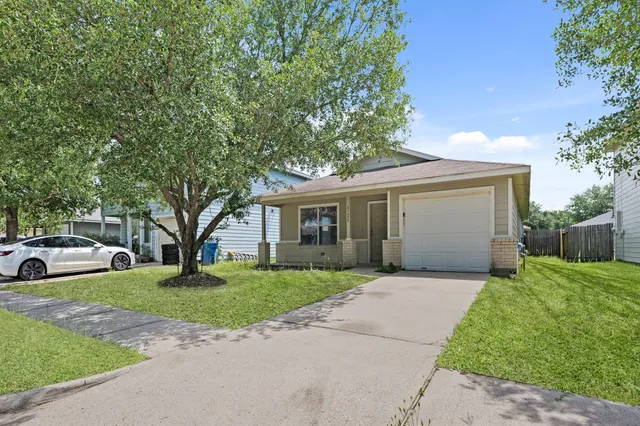 a front view of a house with a garden and trees