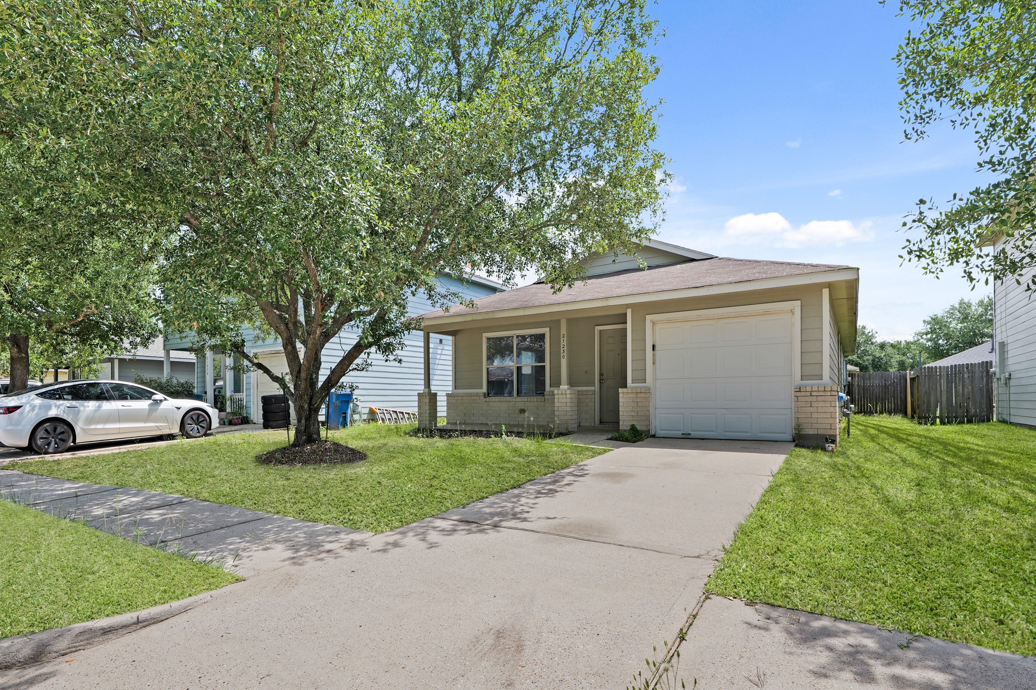 a front view of a house with a garden and trees