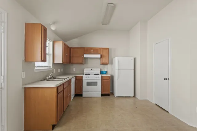 a kitchen with a stove a refrigerator and a sink
