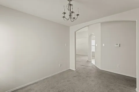 a view of a hallway with a chandelier fan
