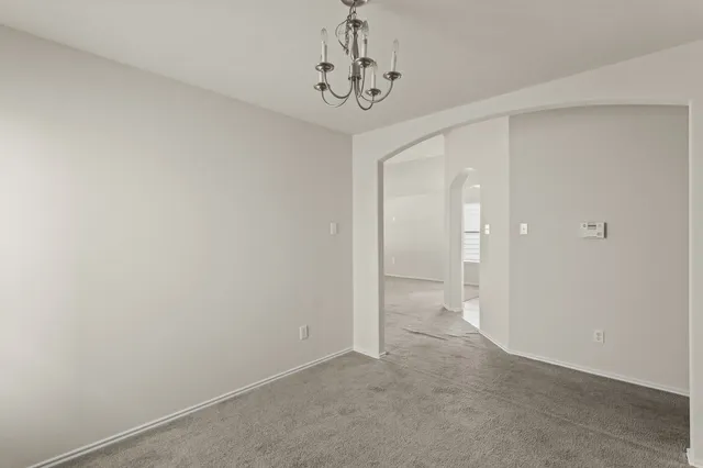 a view of a hallway with a chandelier fan