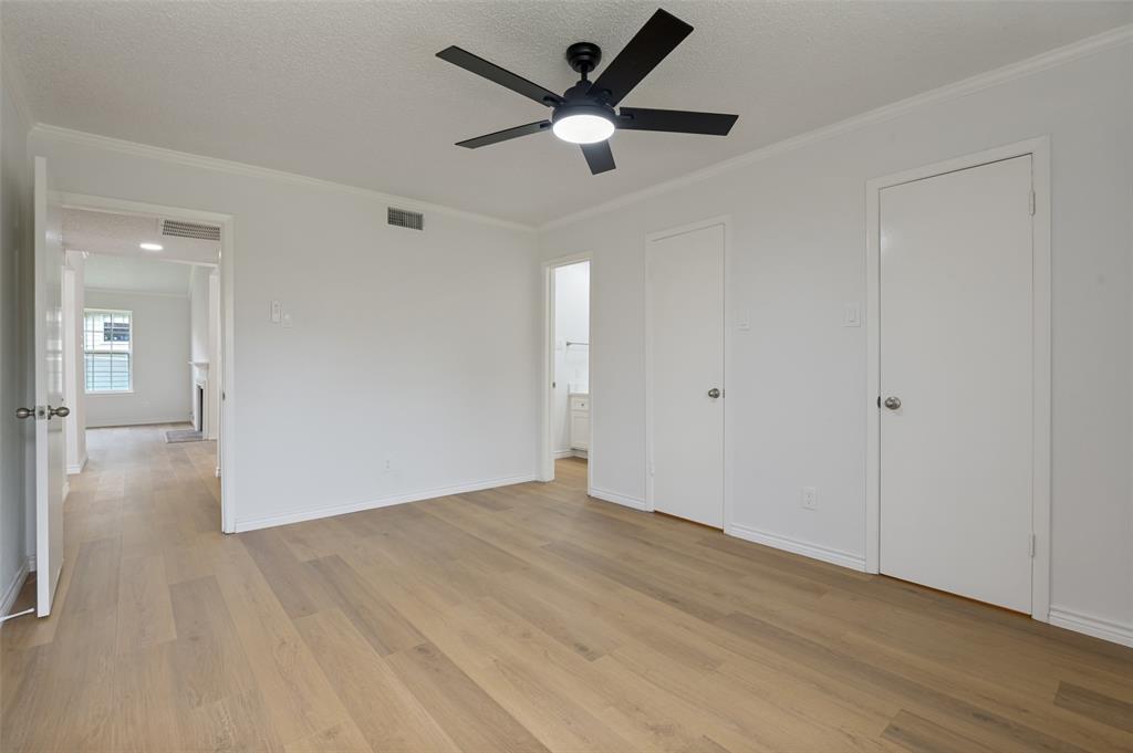 5300 Keller Springs Road, Unit 2042 Dallas, TX 75248 - Photo 20 of 28 Spacious interior room featuring wood-finish flooring, a modern black ceiling fan with integrated lighting, and white walls