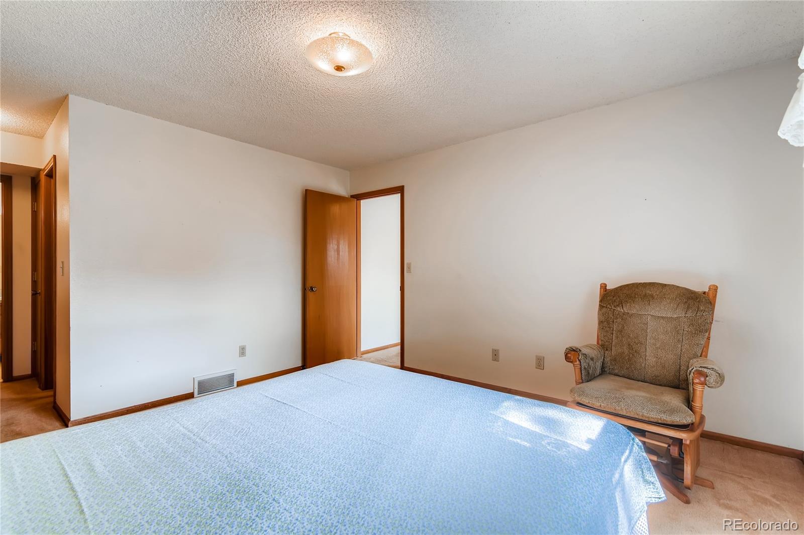 730 Douglas Place Berthoud, CO 80513 - Photo 14 of 28 a bedroom with a chair and wooden floor