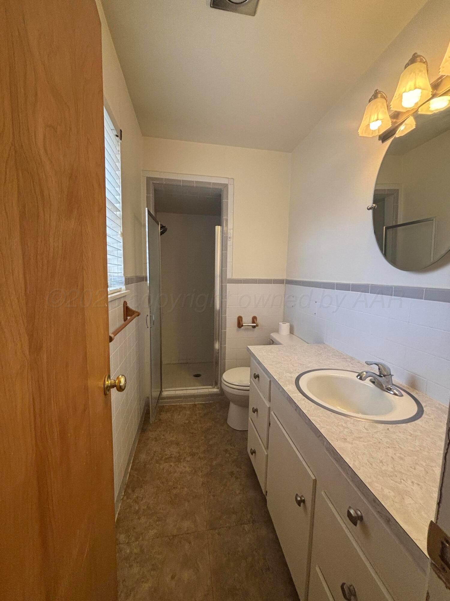 442 Harvey Street Miami, TX 79059 - Photo 7 of 19 a en suite bathroom with a granite countertop sink and a mirror