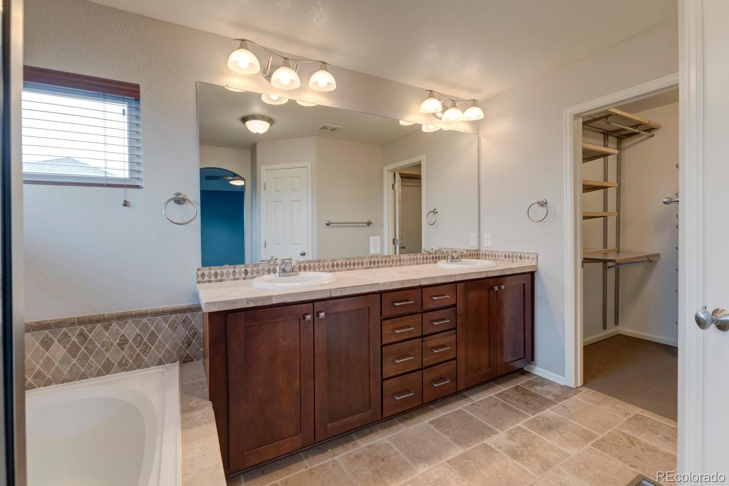 4939 Silver Feather Circle Broomfield, CO 80023 - Photo 15 of 35 a bathroom with a double vanity sink and a mirror