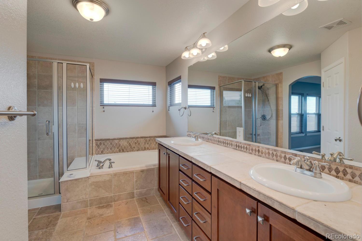 4939 Silver Feather Circle Broomfield, CO 80023 - Photo 16 of 35 a spacious bathroom with a bathtub sink and mirror