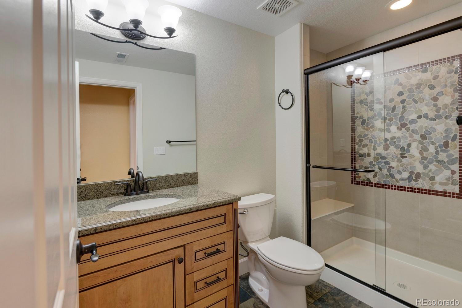 4939 Silver Feather Circle Broomfield, CO 80023 - Photo 21 of 35 a bathroom with a granite countertop sink toilet and shower