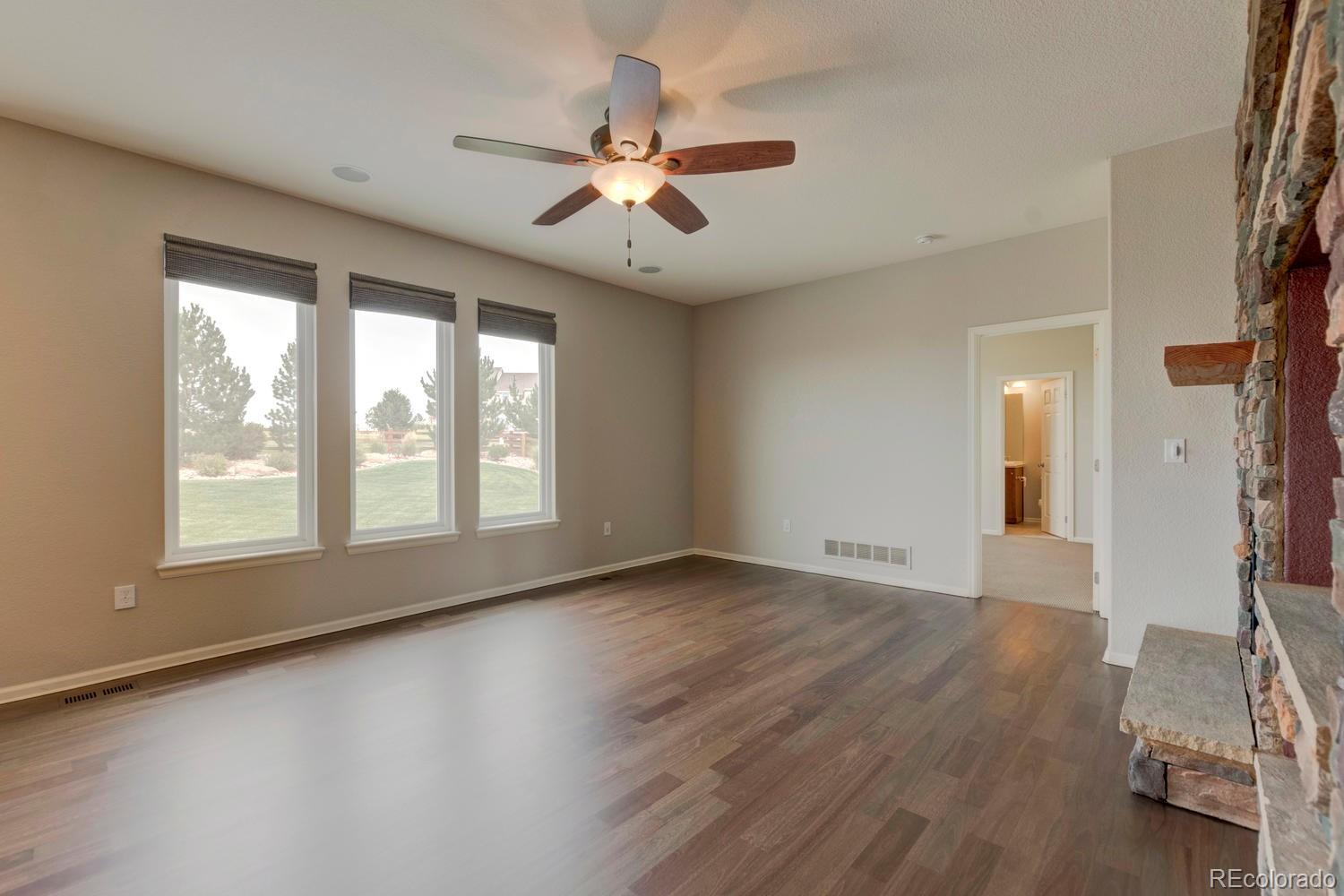 4939 Silver Feather Circle Broomfield, CO 80023 - Photo 6 of 35 a view of an empty room with wooden floor and a window