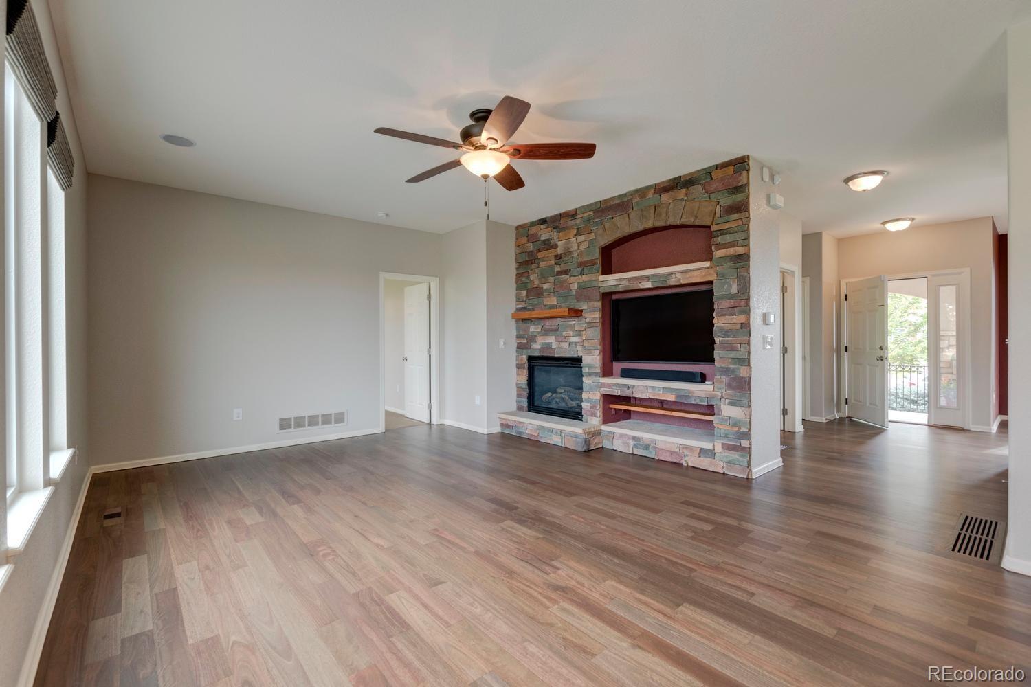4939 Silver Feather Circle Broomfield, CO 80023 - Photo 7 of 35 a view of a livingroom with wooden floor a ceiling fan and windows