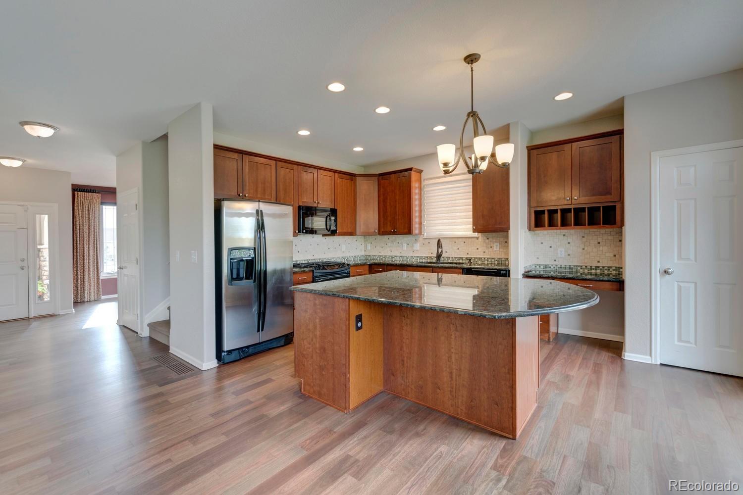 4939 Silver Feather Circle Broomfield, CO 80023 - Photo 10 of 35 a kitchen with stainless steel appliances granite countertop a sink a stove and a wooden floors