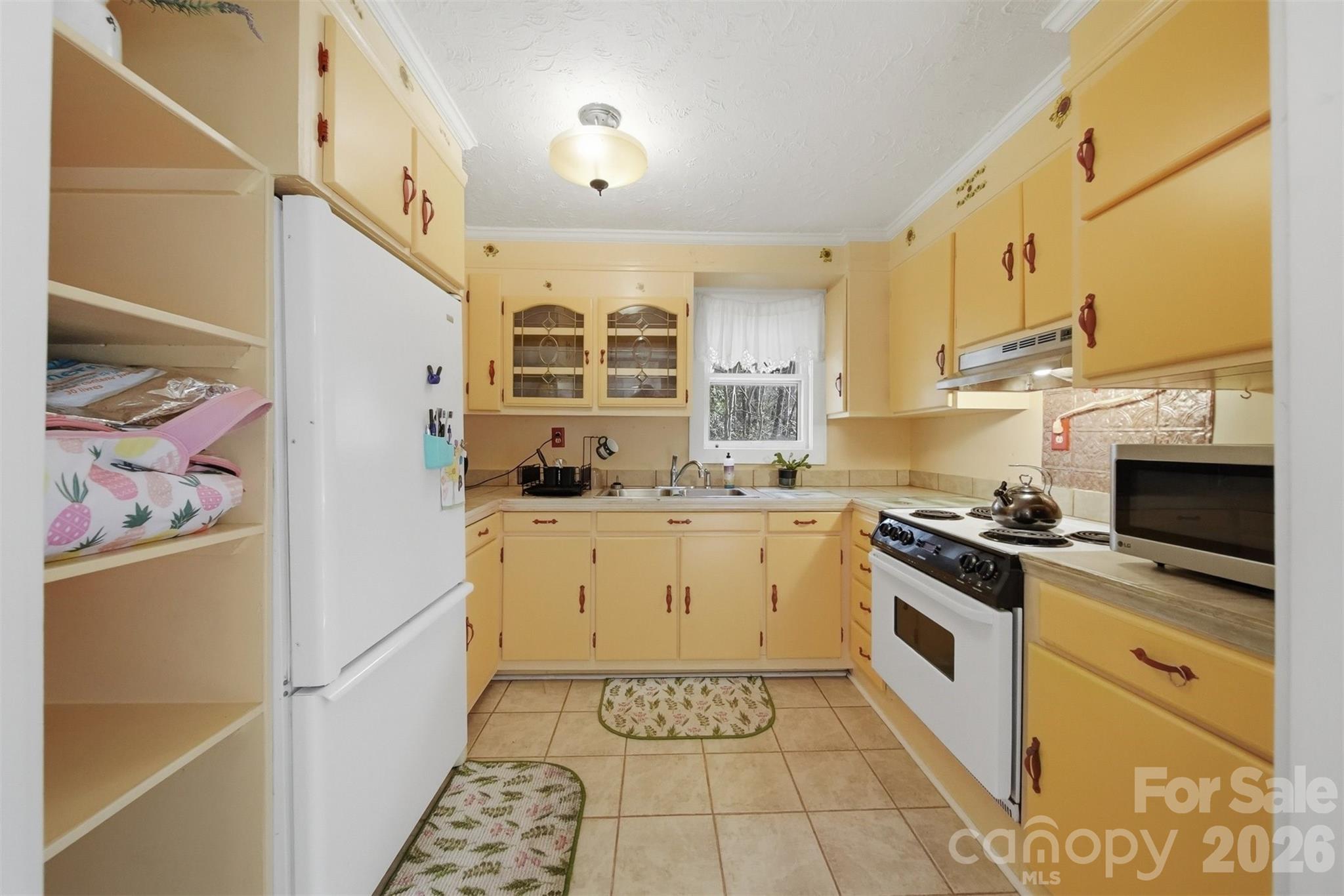 621 Wildlife Lake Road Old Fort, NC 28762 - Photo 11 of 35 a kitchen with a stove a sink and a refrigerator