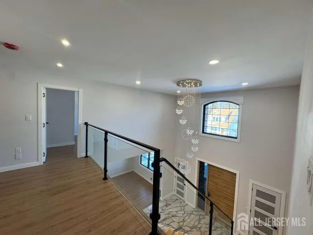 a view of a hallway with a white walls and wooden floor