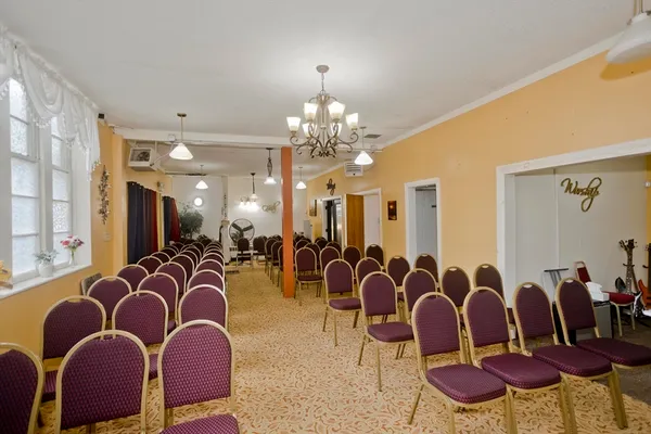 a dinning room with furniture a chandelier and a window