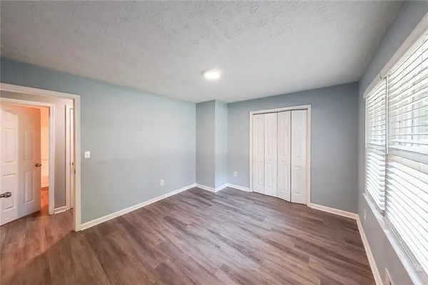 an empty room with wooden floor and windows