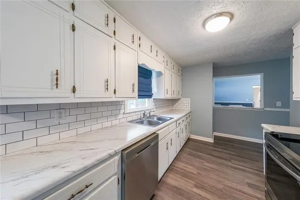 a kitchen with stainless steel appliances granite countertop a sink stove and cabinets