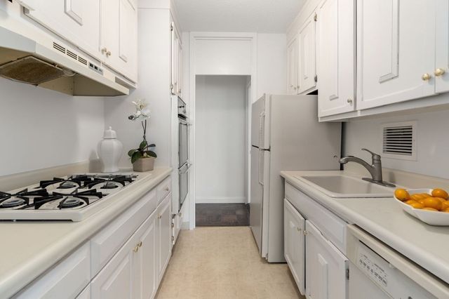 a kitchen with stainless steel appliances granite countertop a sink stove and cabinets