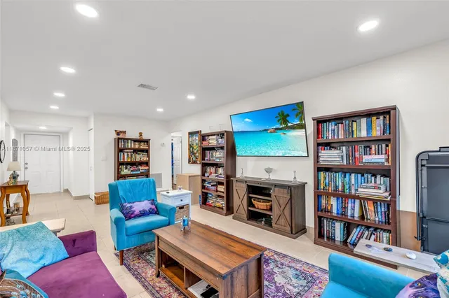 a living room with furniture a rug and a book shelf