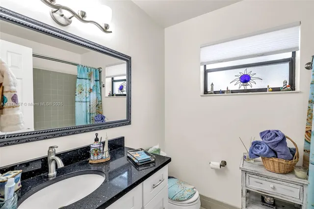 a bathroom with a granite countertop sink and a mirror
