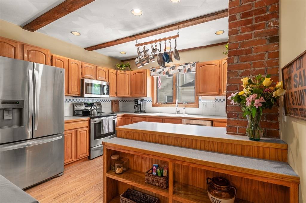 7 Charles Street Danvers, MA 01923 - Photo 4 of 37 a kitchen with stainless steel appliances a sink and a refrigerator