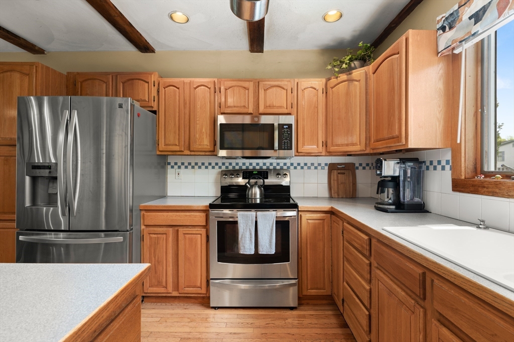 7 Charles Street Danvers, MA 01923 - Photo 5 of 37 a kitchen with stainless steel appliances granite countertop a stove a sink and a refrigerator