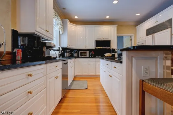 a large kitchen with stainless steel appliances kitchen island granite countertop a stove a sink and a microwave