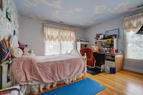 a bedroom with furniture and a wooden floor