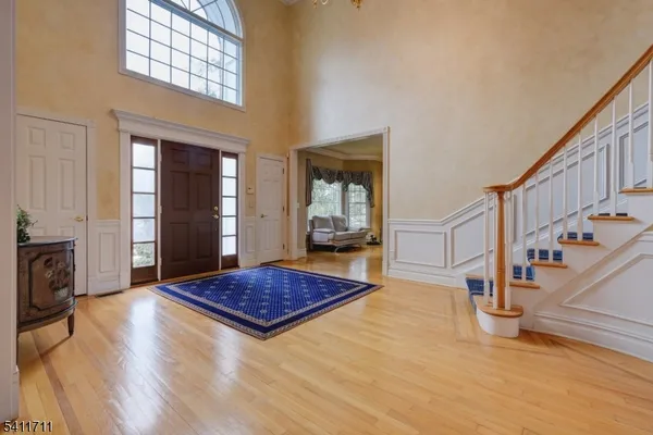 a living room with wooden floor and a rug