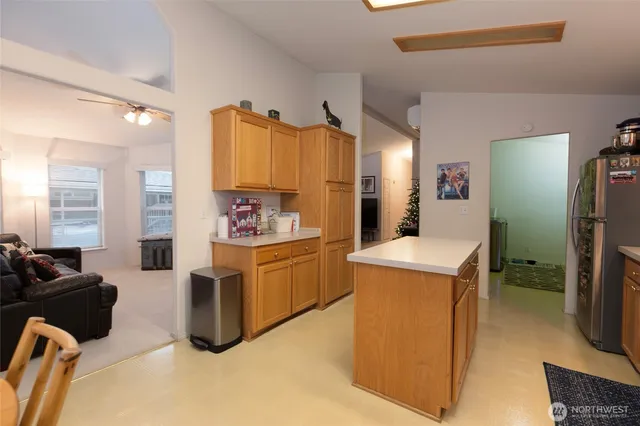a kitchen with stainless steel appliances kitchen island granite countertop a refrigerator and a stove top oven