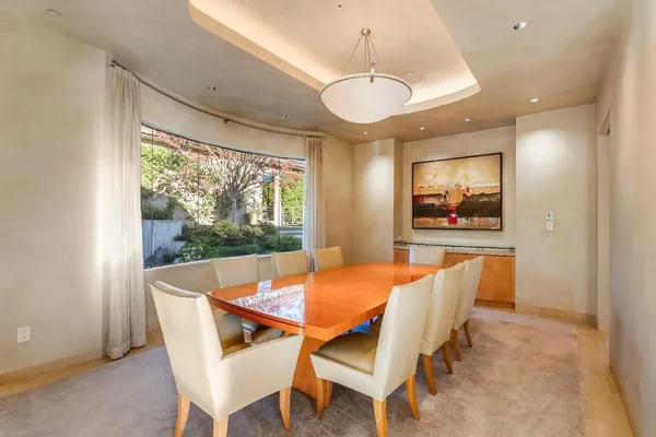 a large kitchen with kitchen island a large counter top space a sink a stove and a window