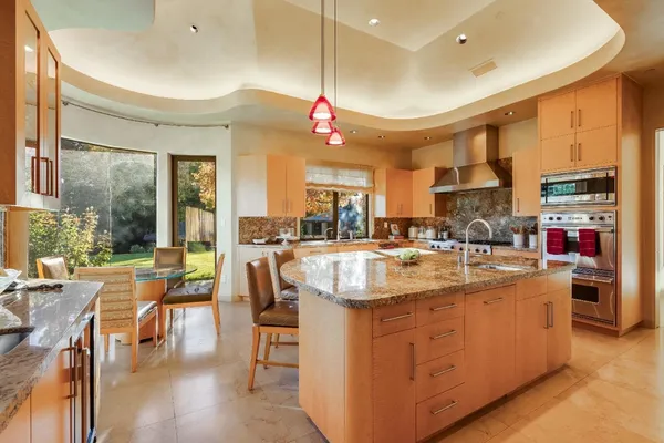 a kitchen with kitchen island granite countertop a sink and a stove