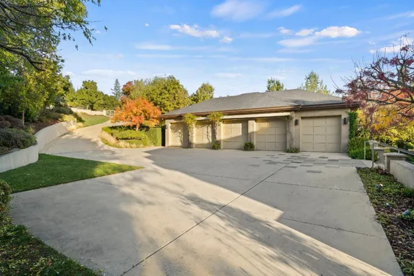 a front view of a house with a yard and trees
