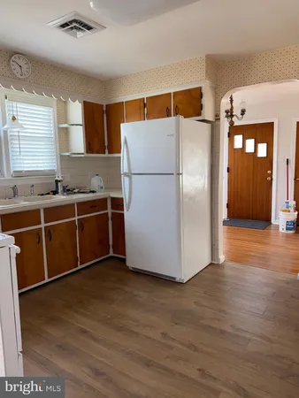a kitchen with stainless steel appliances a refrigerator and wooden floor