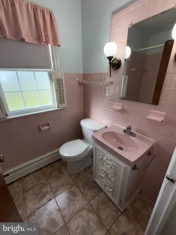 a bathroom with a sink a toilet and mirror