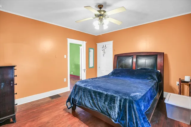 a bedroom with a bed and a table with wooden floor